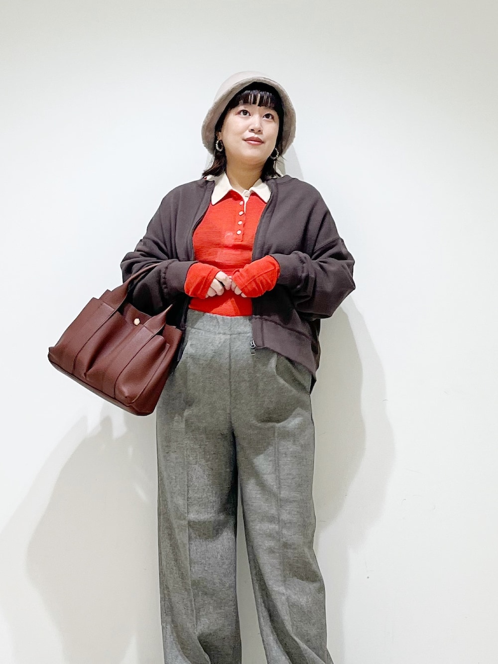 レッド系のニット/セーター、グレー系のその他パンツ、ブラック系のスニーカーを着用したレディースの秋コーディネートの4枚目の写真