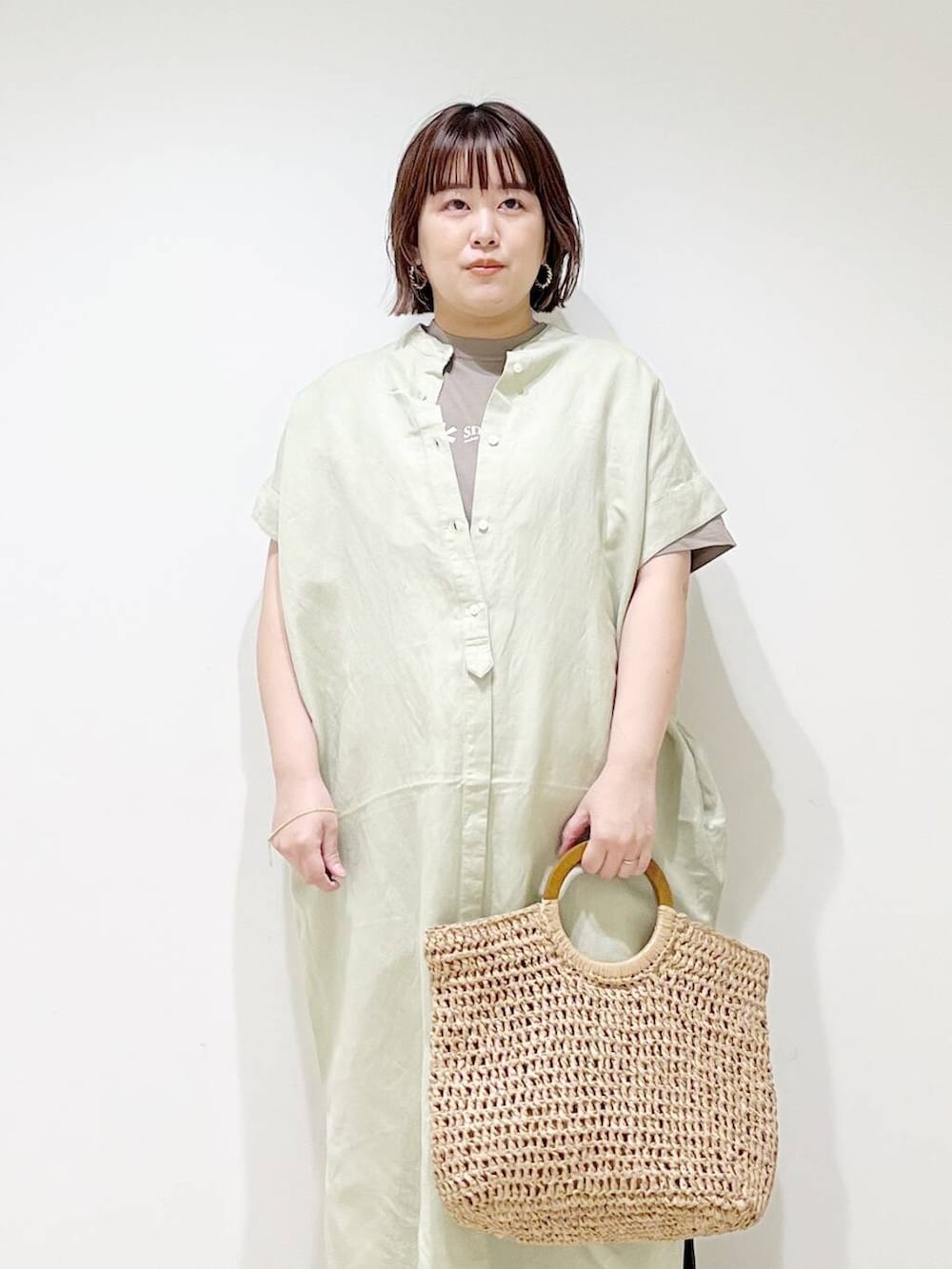 ブラック系のその他パンツ、グリーン系のワンピース、ベージュ系のトートバッグを着用したレディースの春コーディネートの3枚目の写真
