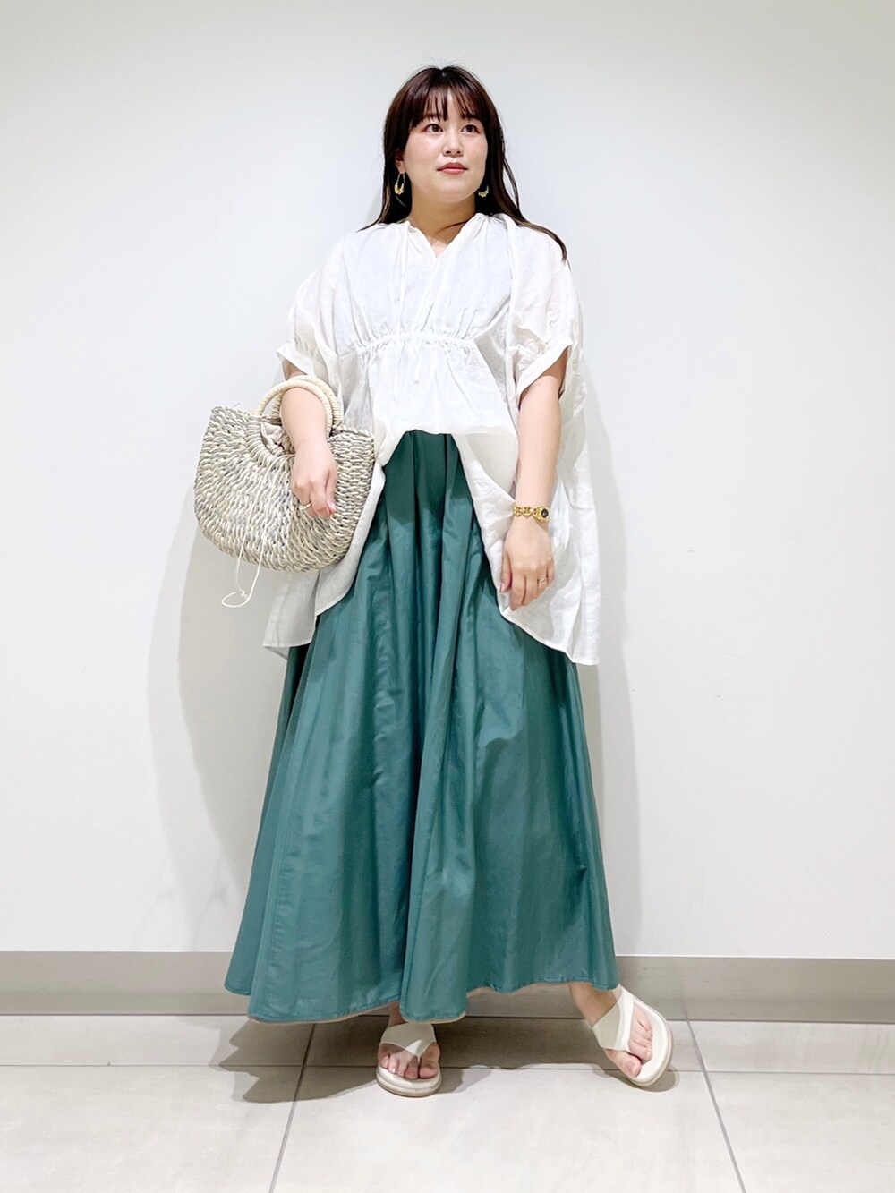 ホワイト系のシャツ/ブラウス、グリーン系のスカート、グレー系のかごバッグを着用したレディースの夏コーディネートの9枚目の写真