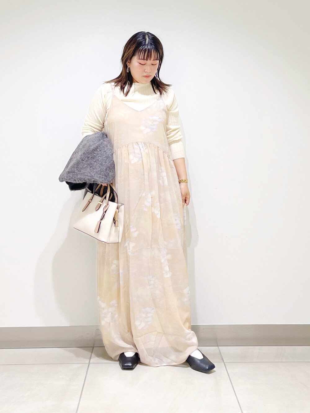 ベージュ系のワンピース、ホワイト系のトートバッグ、ホワイト系のニット/セーターを着用したレディースの秋コーディネートの3枚目の写真