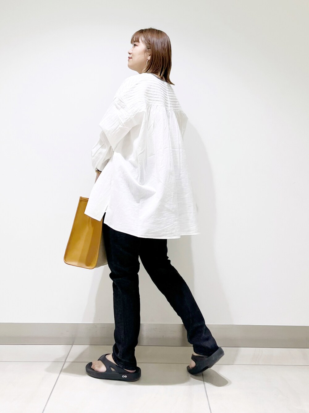 ホワイト系のシャツ/ブラウス、イエロー系のトートバッグ、ブラック系のデニムパンツを着用したレディースの春コーディネートの4枚目の写真