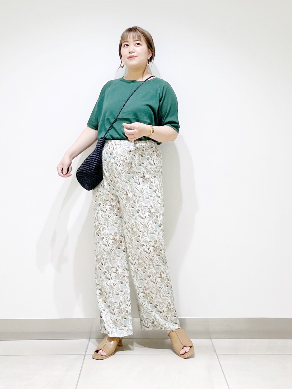 グリーン系のTシャツ/カットソー、ホワイト系のその他パンツ、ベージュ系のサンダルを着用したレディースの夏コーディネートの2枚目の写真