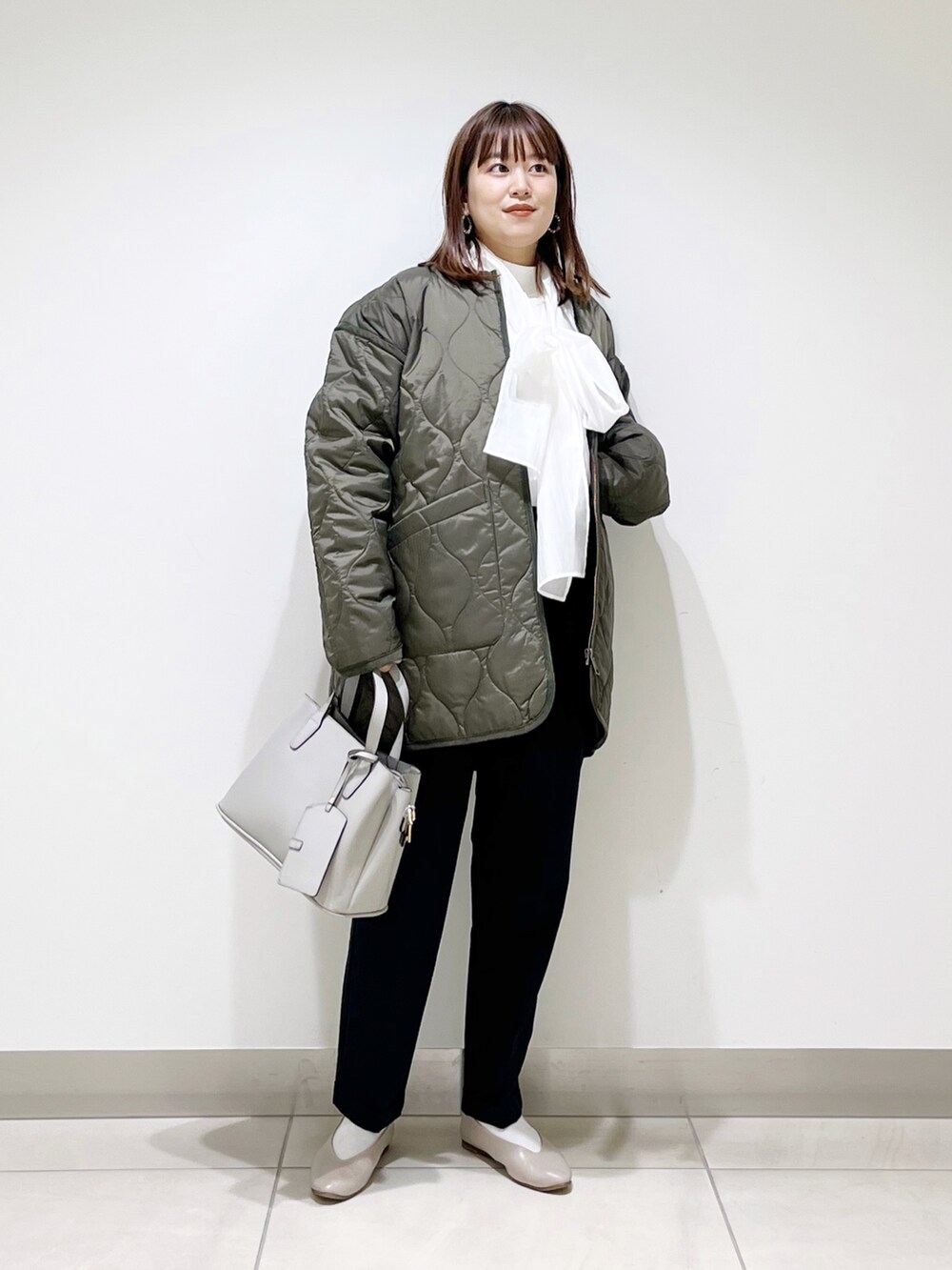 グリーン系のダウンジャケット/コート、ブルー系のパンツ、グレー系のトートバッグを着用したレディースの秋コーディネートの10枚目の写真