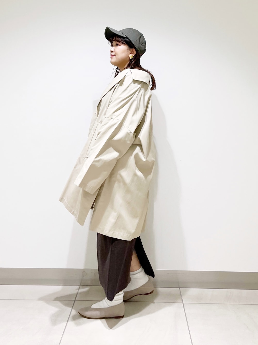 ベージュ系のポンチョ、ブラウン系のワンピース、ベージュ系のパンプスを着用したレディースの春コーディネートの4枚目の写真