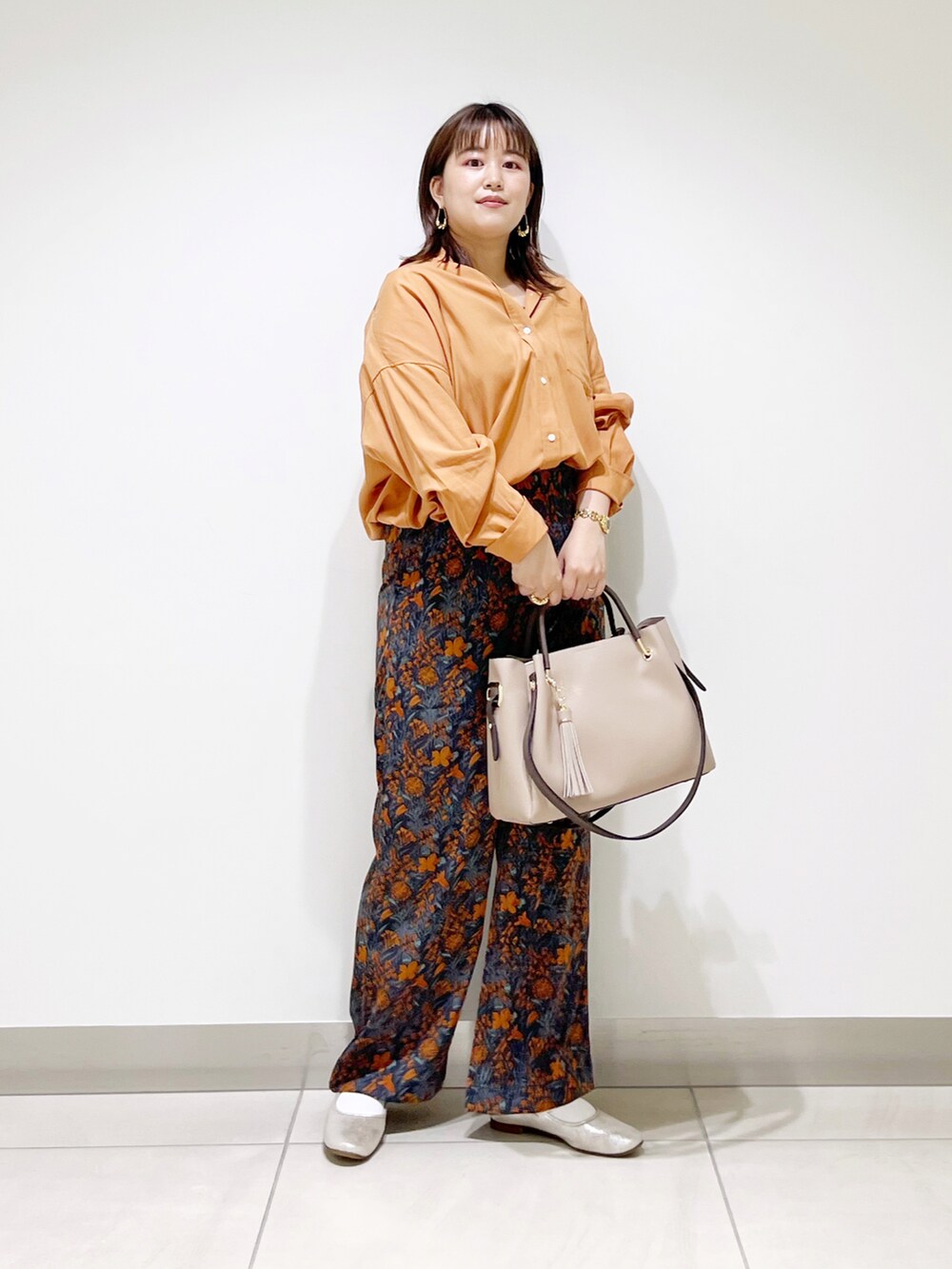 オレンジ系のシャツ/ブラウス、ベージュ系のトートバッグ、ゴールド系のその他シューズを着用したレディースの夏コーディネートの4枚目の写真
