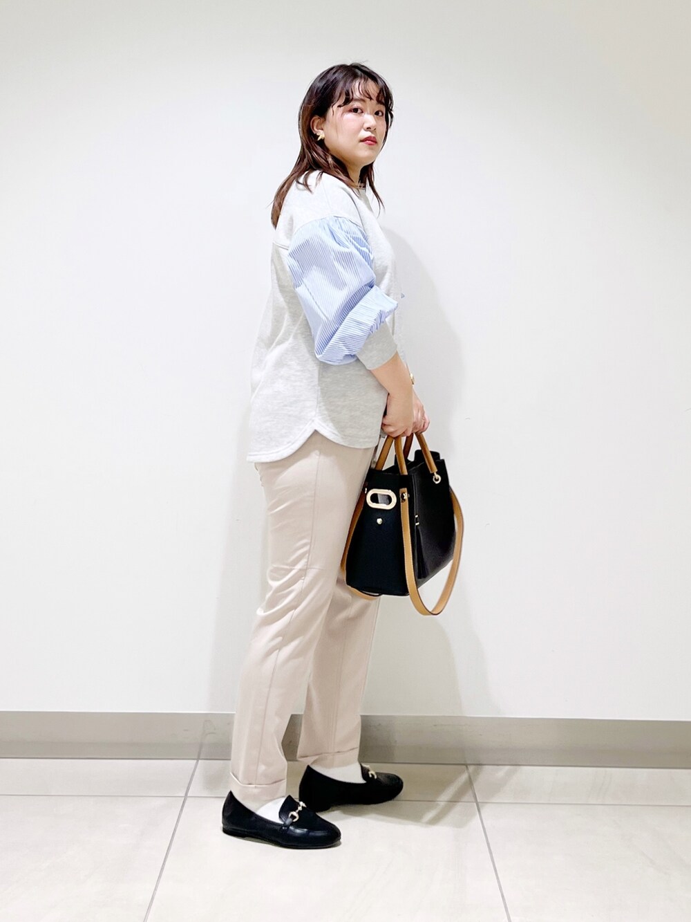 グレー系のTシャツ/カットソー、ベージュ系のその他パンツ、ブラック系のトートバッグを着用したレディースの春コーディネートの4枚目の写真