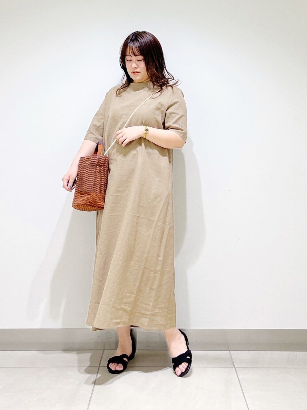 ベージュ系のワンピース、ブラウン系のショルダーバッグ、ブラック系のサンダルを着用したレディースの春コーディネートの3枚目の写真