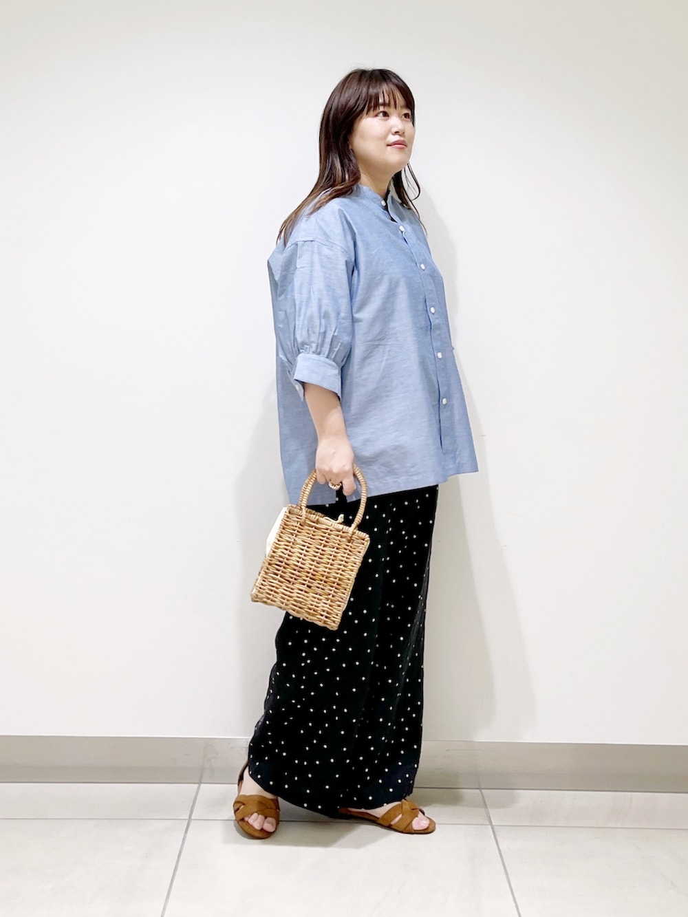 ブルー系のシャツ/ブラウス、ブラック系のその他パンツ、ベージュ系のハンドバッグを着用したレディースの夏コーディネートの2枚目の写真