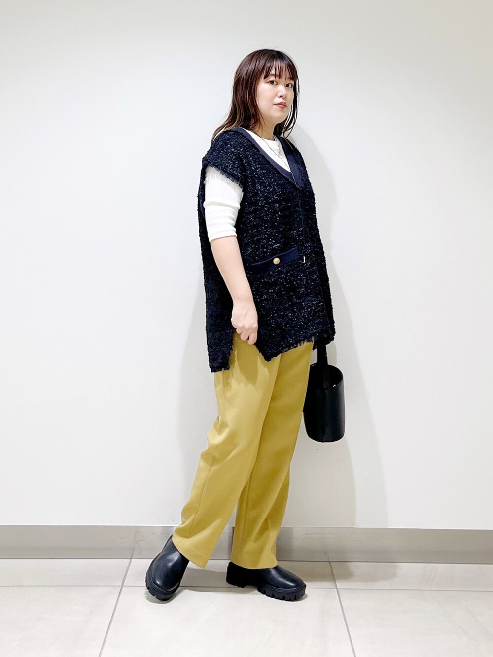 ブラック系のトップス、イエロー系のその他パンツ、ブラック系のショルダーバッグを着用したレディースの夏コーディネートの2枚目の写真