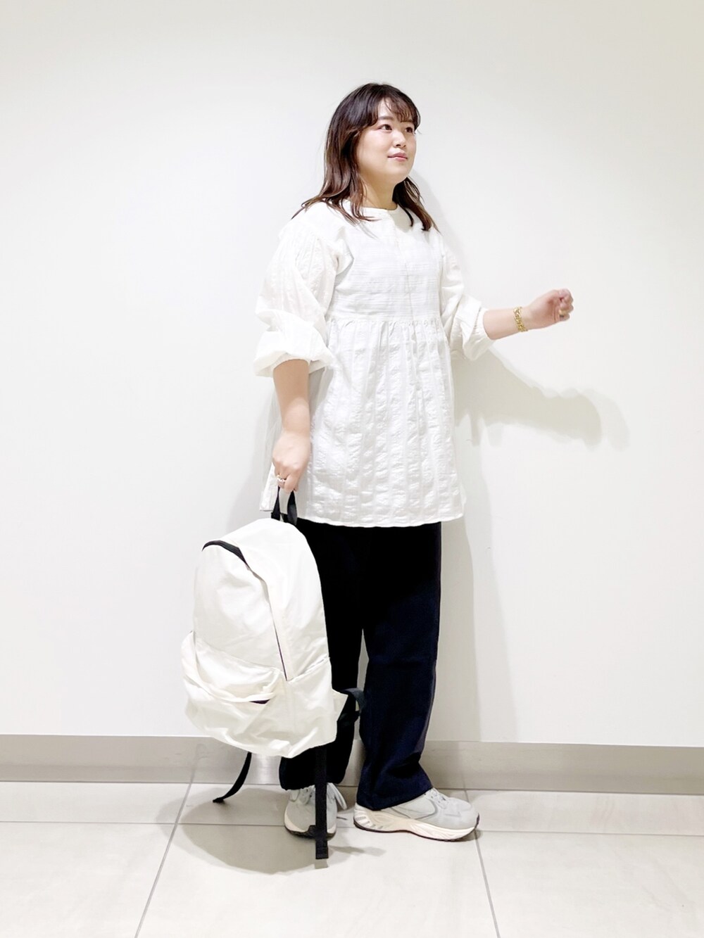 ホワイト系のシャツ/ブラウス、ブルー系のその他パンツ、ホワイト系のバックパック/リュックを着用したレディースの春コーディネートの4枚目の写真