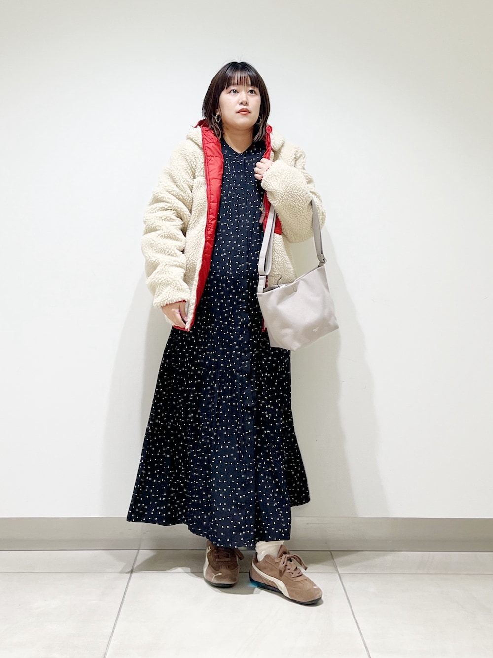 レッド系のその他アウター、ブラック系のワンピース、グレー系のショルダーバッグを着用したレディースの秋コーディネートの2枚目の写真
