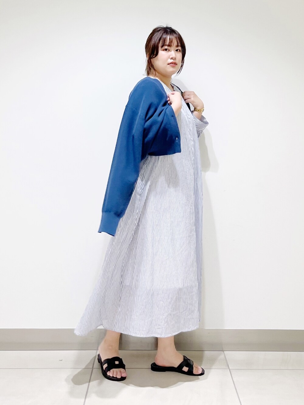 ブルー系のワンピース、ブルー系のニット/セーター、ブラック系のサンダルを着用したレディースの春コーディネートの5枚目の写真