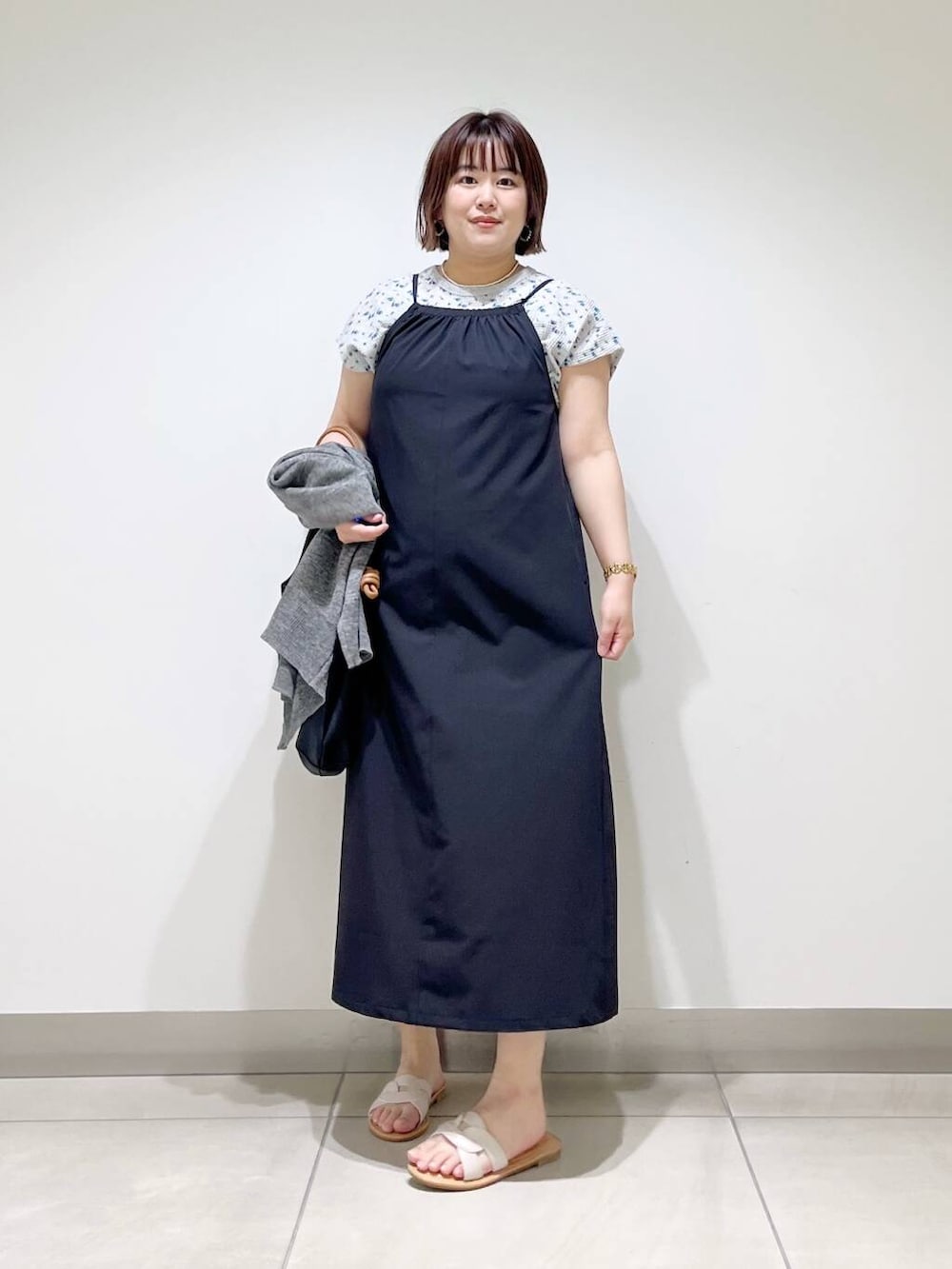 ブラック系のトートバッグ、グレー系のカーディガン/ボレロ、ホワイト系のサンダルを着用したレディースの春コーディネートの4枚目の写真