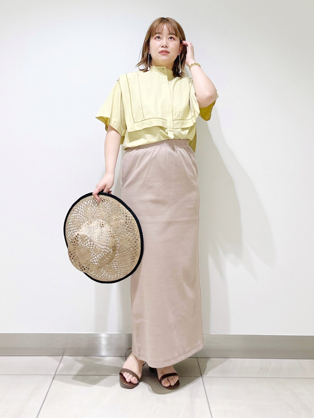 イエロー系のシャツ/ブラウス、ブラウン系のサンダル、ベージュ系のスカートを着用したレディースの夏コーディネートの3枚目の写真
