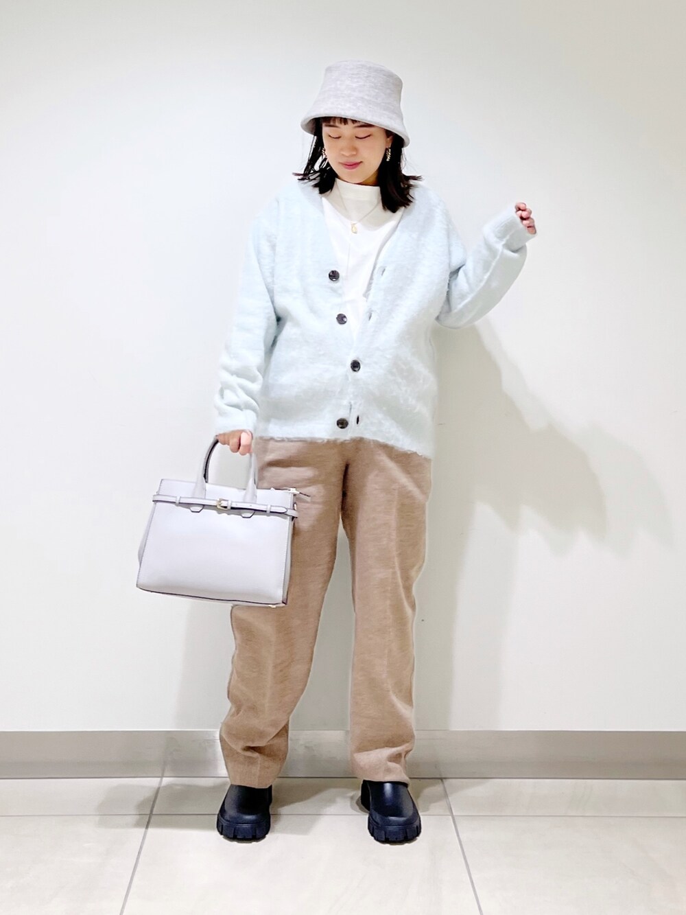 グリーン系のカーディガン/ボレロ、ベージュ系のその他パンツ、ブラック系のブーツを着用したレディースの秋コーディネートの5枚目の写真