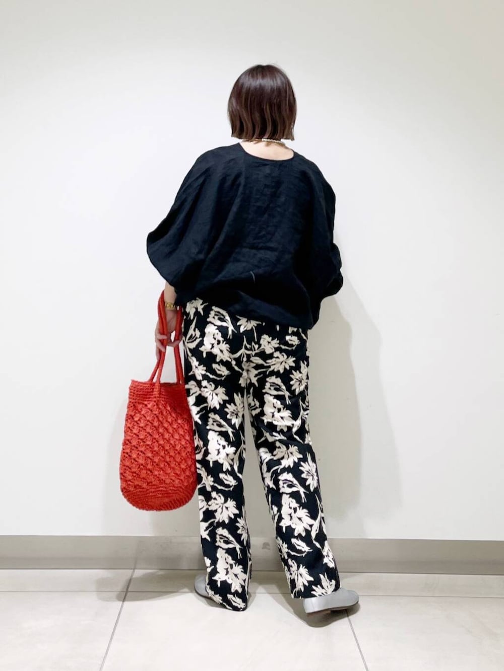 シルバー系のパンプス、ブラック系のその他パンツ、オレンジ系のトートバッグを着用したレディースの春コーディネートの6枚目の写真