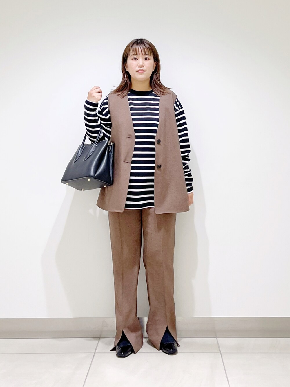 ブラウン系のベスト、ブラウン系のその他パンツ、ブラック系のTシャツ/カットソーを着用したレディースの夏コーディネートの2枚目の写真