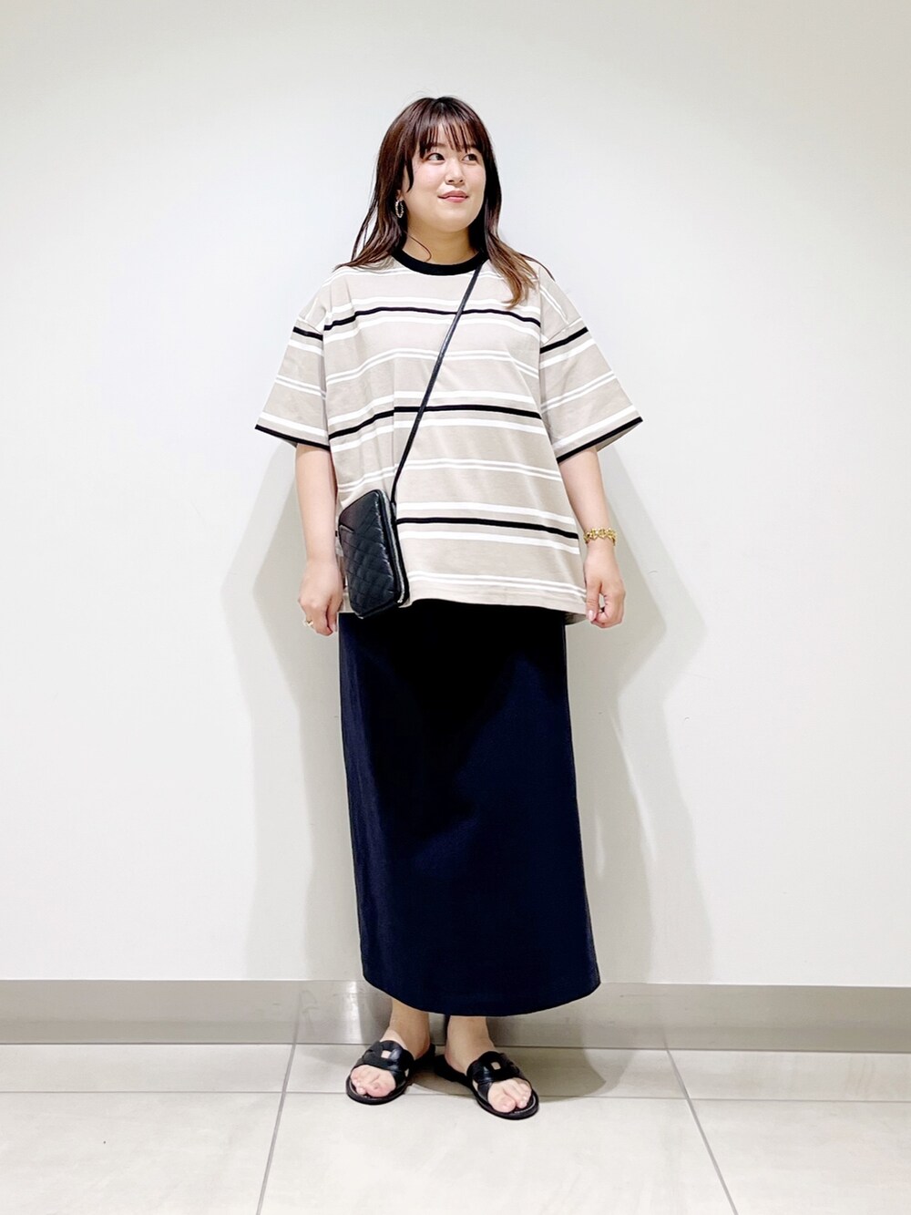 ベージュ系のTシャツ/カットソー、ブルー系のスカート、ブラック系のショルダーバッグを着用したレディースの夏コーディネートの5枚目の写真