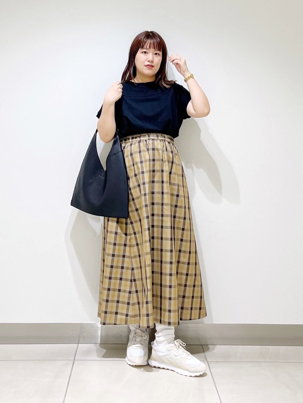 ホワイト系のスニーカー、ブラック系のTシャツ/カットソー、ブラック系のトートバッグを着用したレディースの秋コーディネートの7枚目の写真