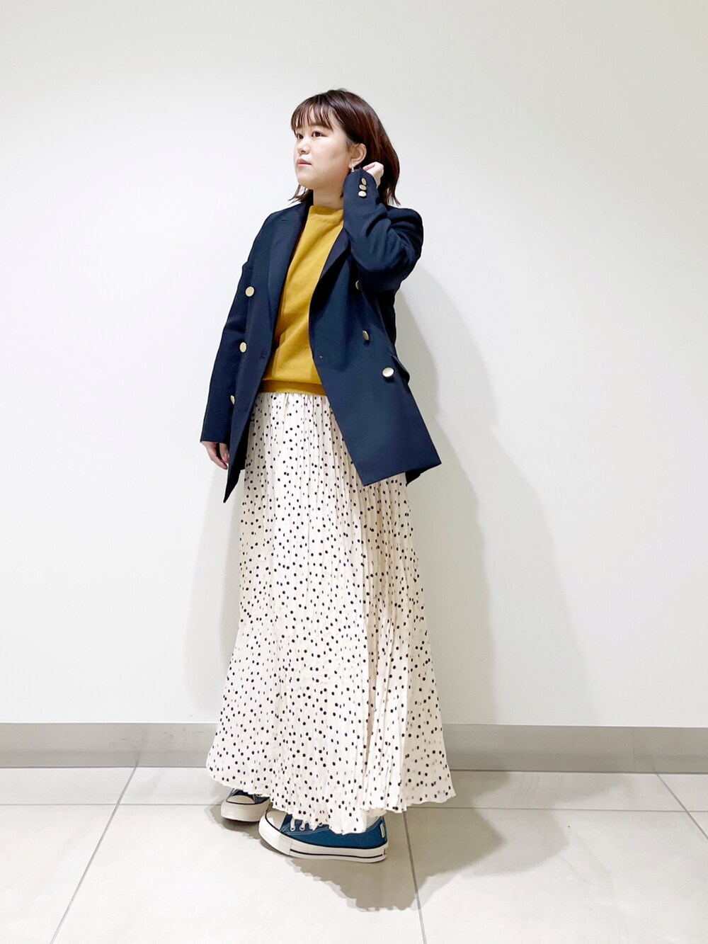 ブルー系のその他アウター、イエロー系のニット/セーター、ホワイト系のスカートを着用したレディースの冬コーディネートの2枚目の写真