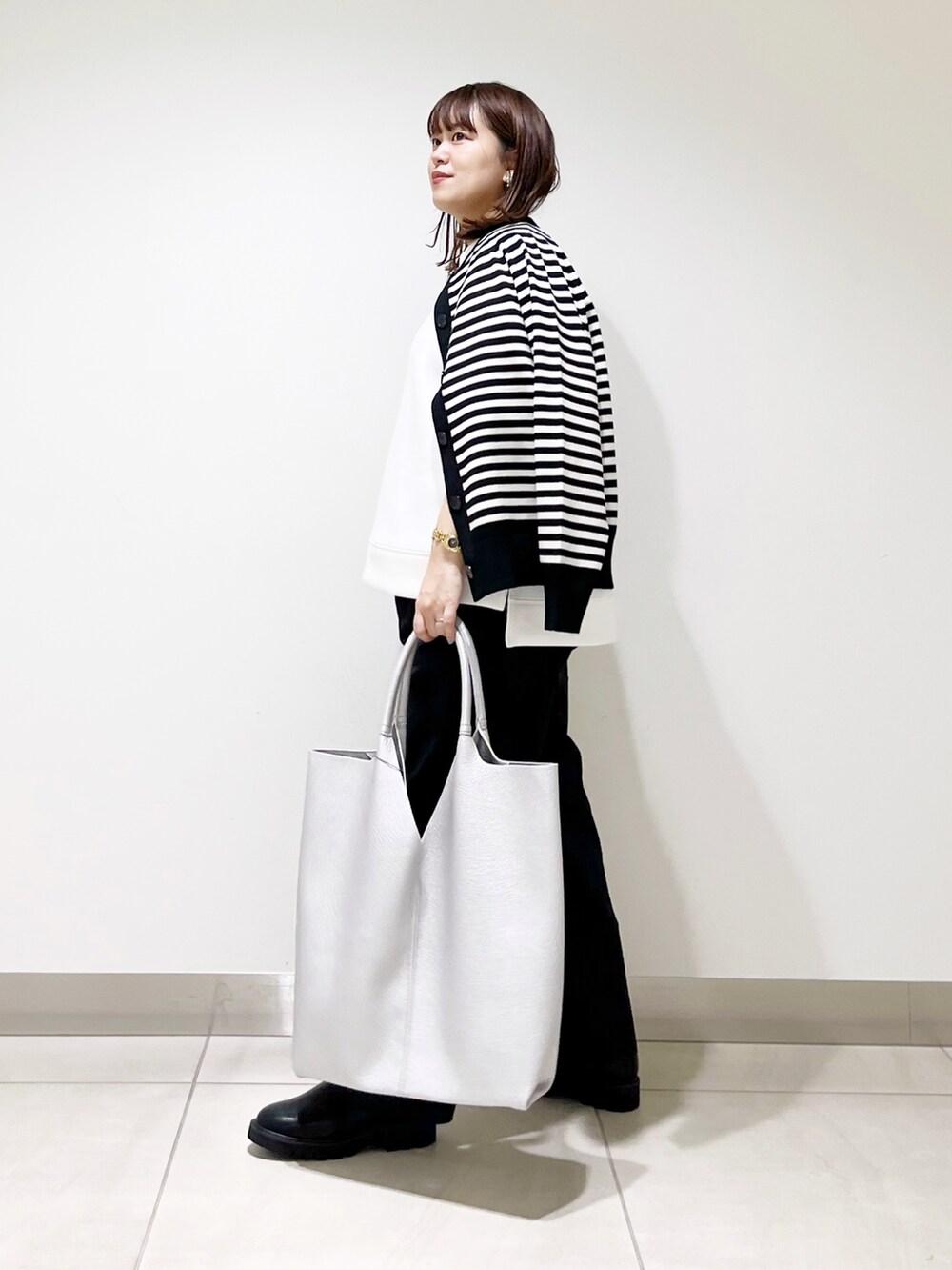 ホワイト系のTシャツ/カットソー、ブラック系のカーディガン/ボレロ、ブルー系のその他パンツを着用したレディースの秋コーディネートの4枚目の写真