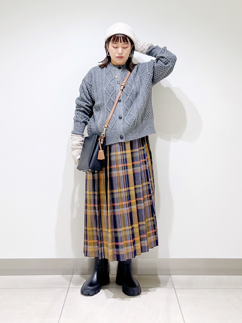 グレー系のカーディガン/ボレロ、ブルー系のスカート、ブラック系のショルダーバッグを着用したレディースの冬コーディネートの9枚目の写真