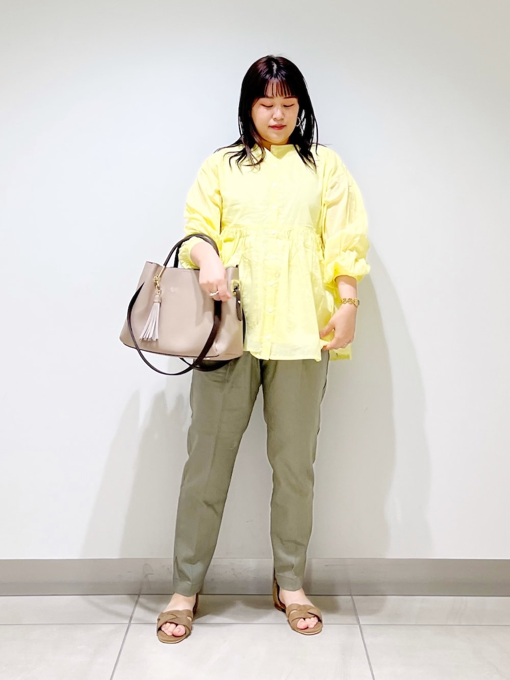 イエロー系のシャツ/ブラウス、グリーン系のその他パンツ、ベージュ系のトートバッグを着用したレディースの春コーディネートの10枚目の写真
