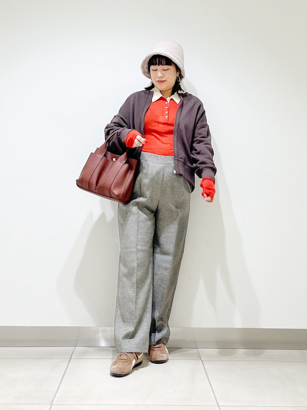 レッド系のニット/セーター、グレー系のその他パンツ、ブラック系のスニーカーを着用したレディースの秋コーディネートの3枚目の写真