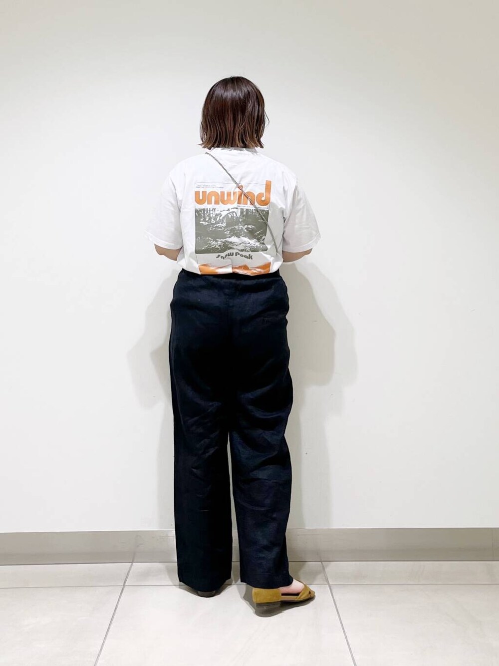 ブラック系のショルダーバッグ、ブラック系のその他パンツ、イエロー系のサンダルを着用したレディースの春コーディネートの4枚目の写真