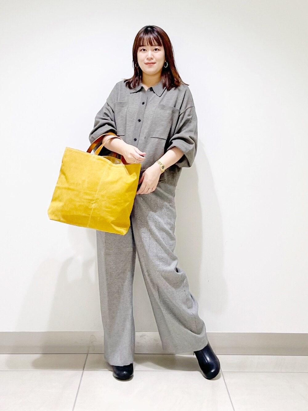 グレー系のニット/セーター、ベージュ系のパンツ、イエロー系のトートバッグを着用したレディースの秋コーディネートの8枚目の写真