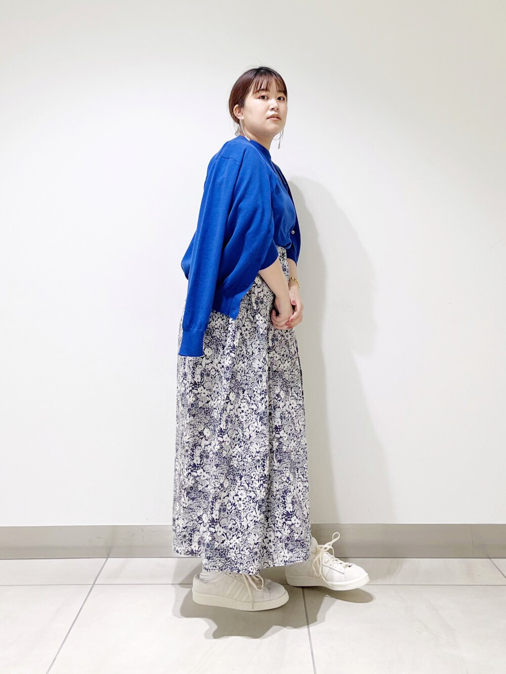 ブルー系のニット/セーター、ブルー系のカーディガン/ボレロ、ブルー系のスカートを着用したレディースの冬コーディネートの2枚目の写真