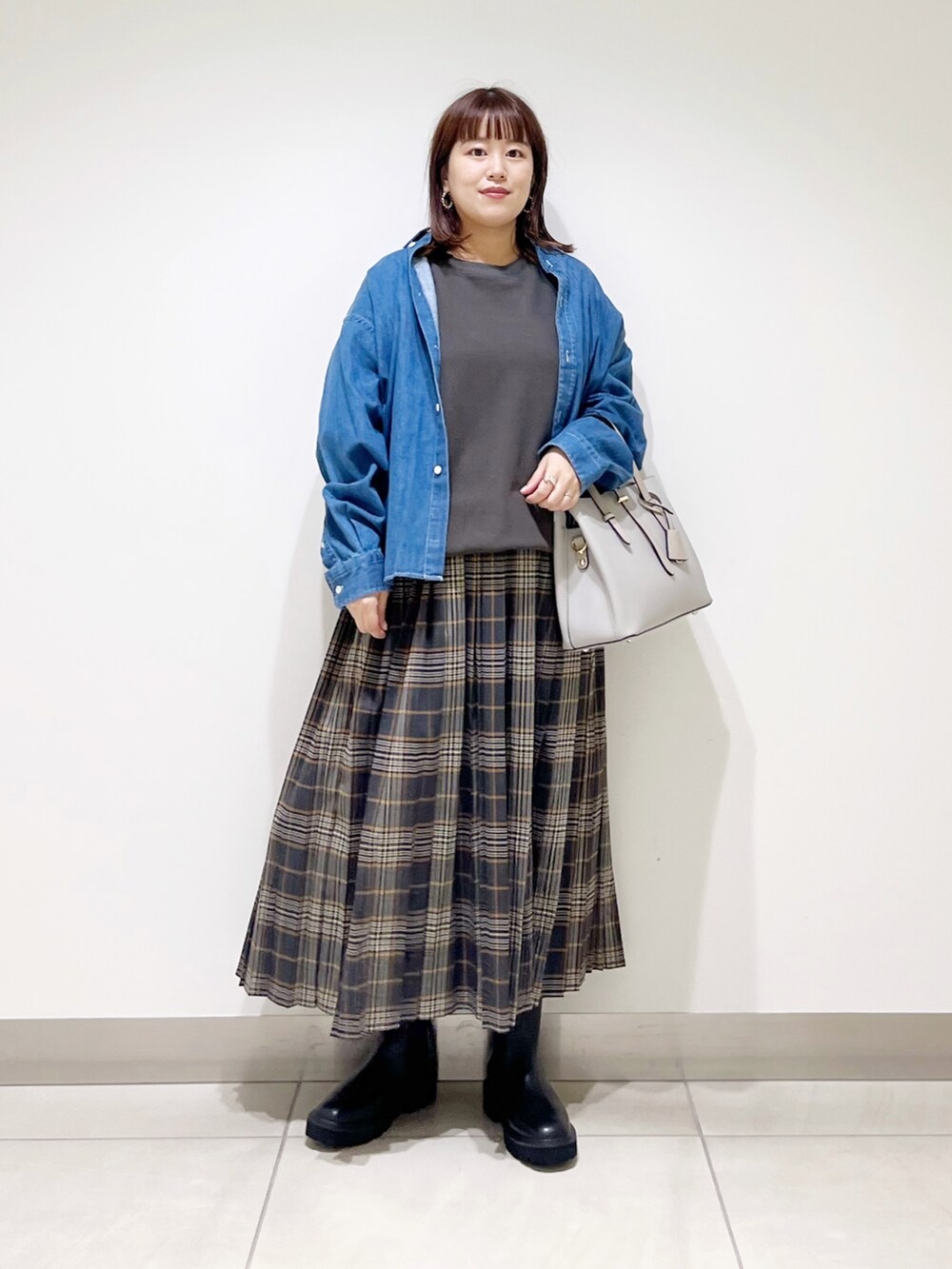 グレー系のTシャツ/カットソー、グレー系のトートバッグ、グレー系のスカートを着用したレディースの秋コーディネートの6枚目の写真