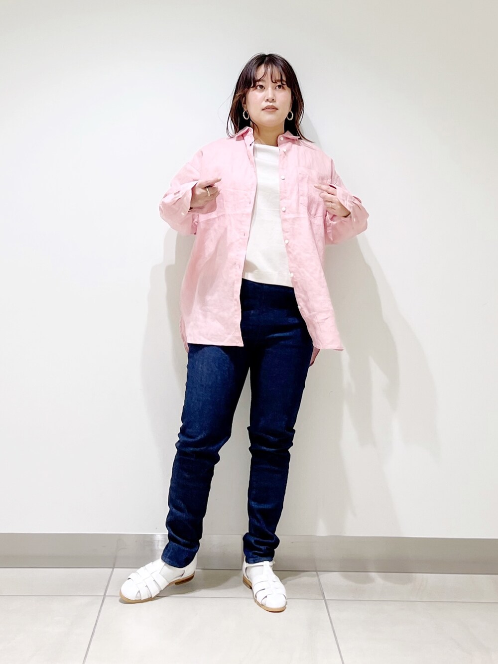 ピンク系のシャツ/ブラウス、ベージュ系のTシャツ/カットソー、ブルー系のデニムパンツを着用したレディースの春コーディネートの5枚目の写真