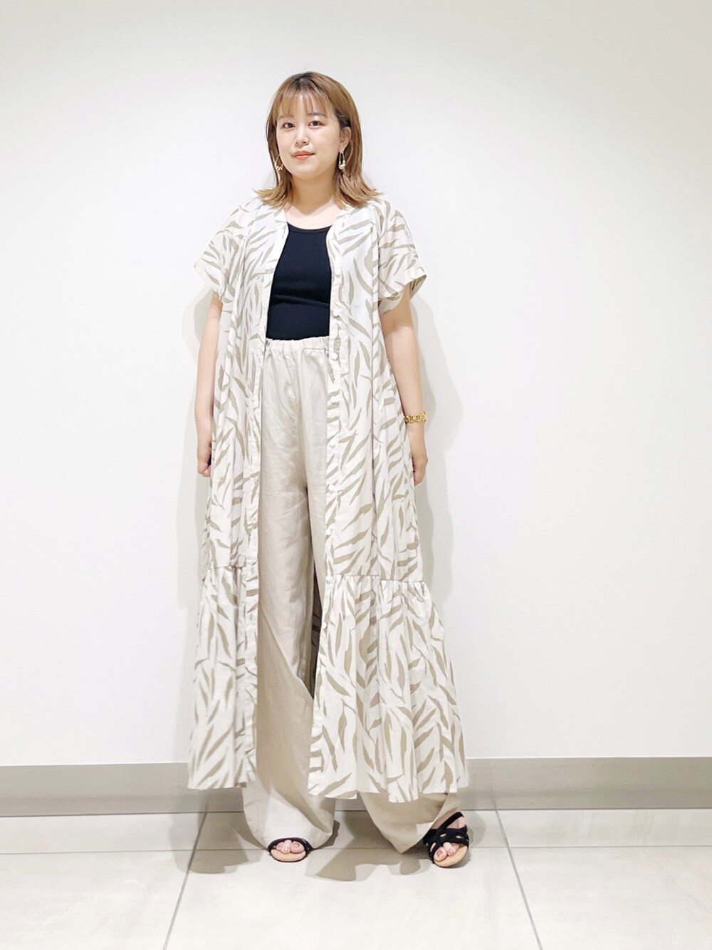 ベージュ系のワンピース、ベージュ系のその他パンツ、ブラック系のサンダルを着用したレディースの夏コーディネートの3枚目の写真