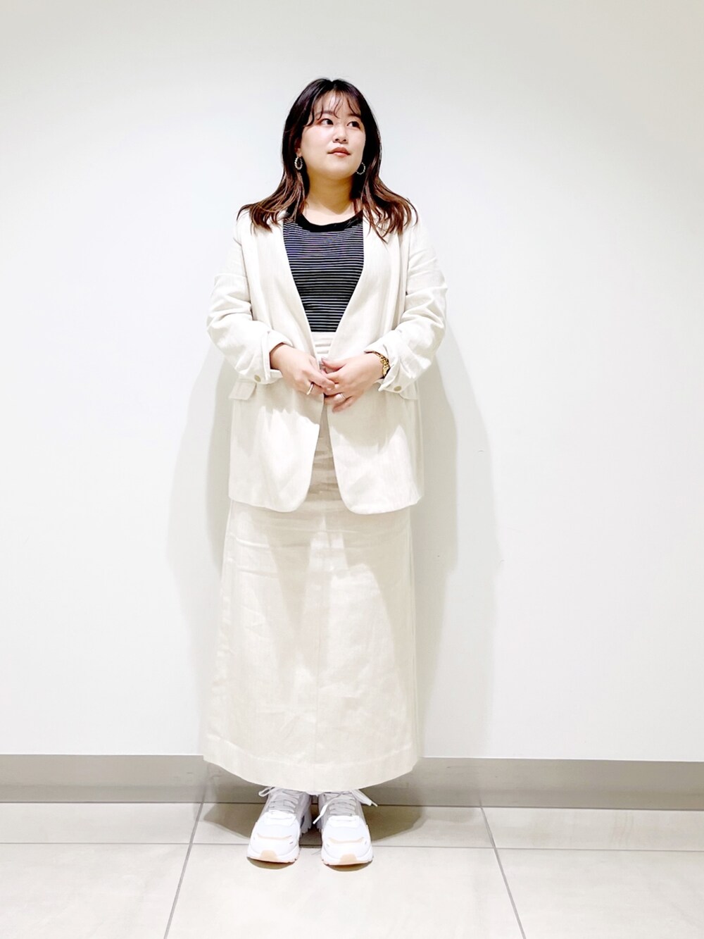 ベージュ系のスカート、ベージュ系のノーカラージャケット、ホワイト系のTシャツ/カットソーを着用したレディースの春コーディネートの5枚目の写真