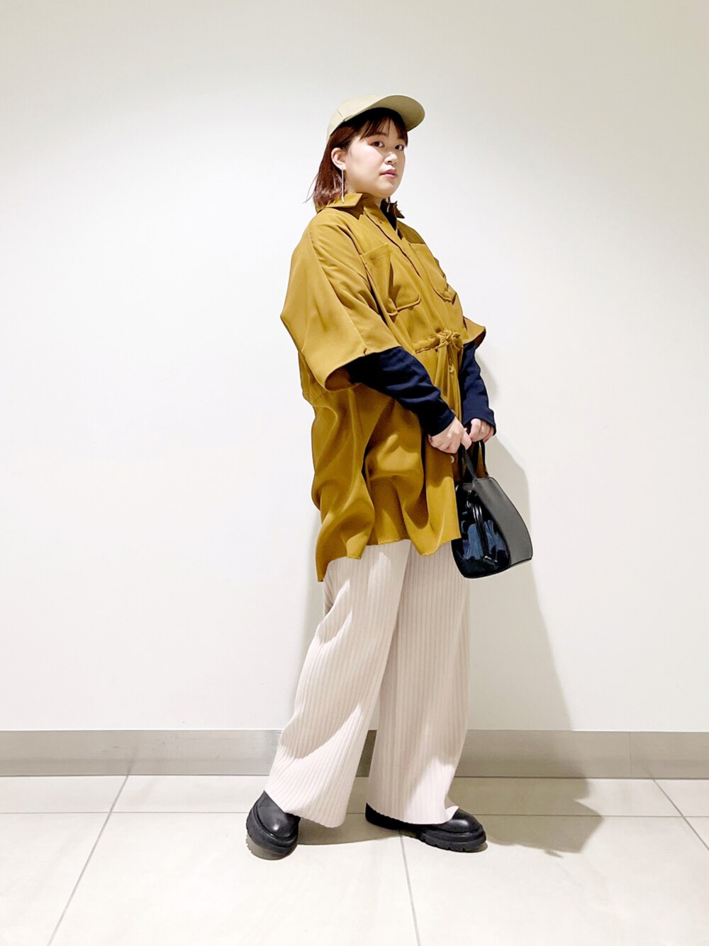 ブラウン系のシャツ/ブラウス、ブラック系のショルダーバッグ、ベージュ系のその他パンツを着用したレディースの冬コーディネートの2枚目の写真