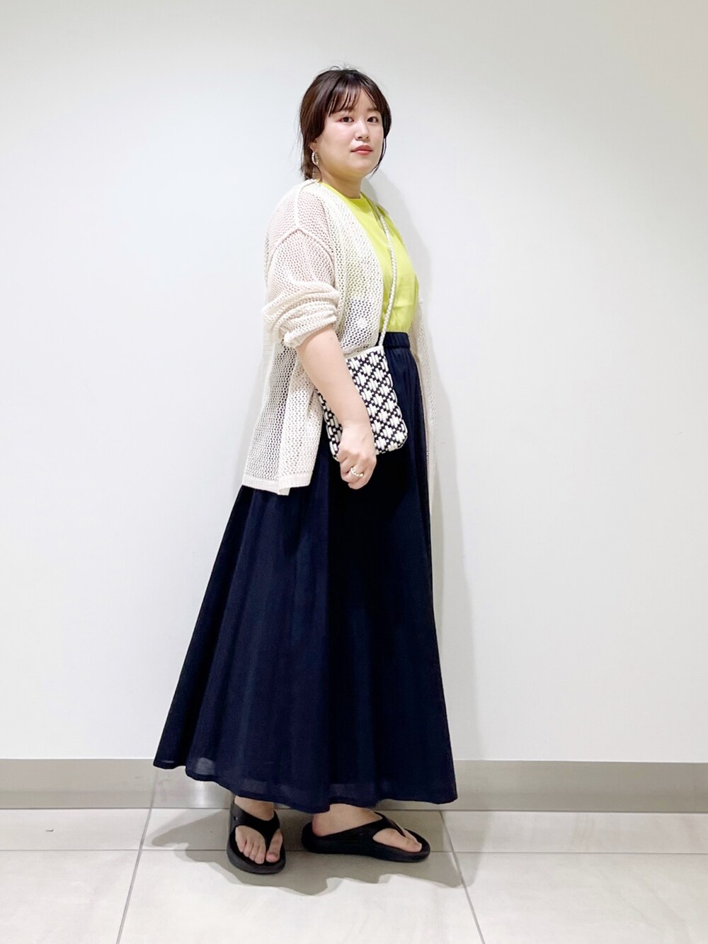 ホワイト系のカーディガン/ボレロ、ブラック系のショルダーバッグ、ブルー系のスカートを着用したレディースの春コーディネートの5枚目の写真