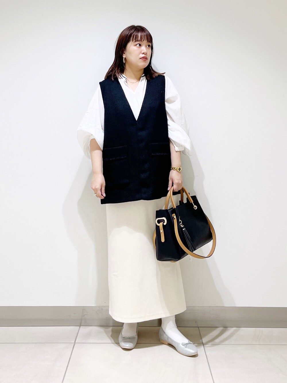 ブラック系のトップス、ホワイト系のシャツ/ブラウス、その他のスカートを着用したレディースの秋コーディネートの7枚目の写真