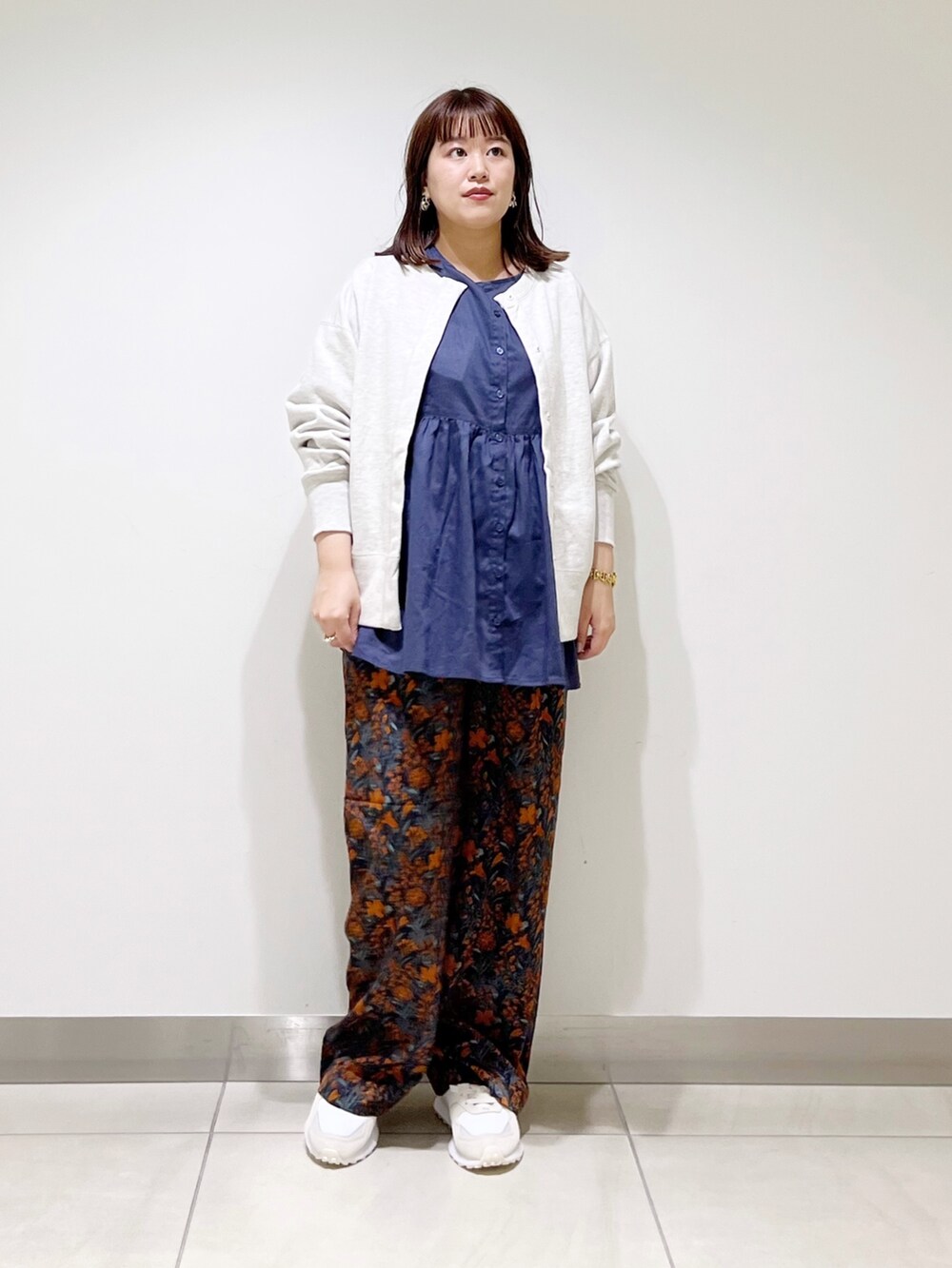 グレー系のカーディガン/ボレロ、ブルー系のシャツ/ブラウス、グレー系のトートバッグを着用したレディースの秋コーディネートの2枚目の写真