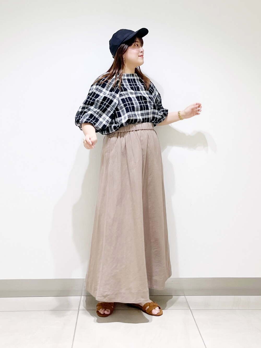 ベージュ系のスカート、ベージュ系のサンダル、ブラック系のシャツ/ブラウスを着用したレディースの夏コーディネートの7枚目の写真