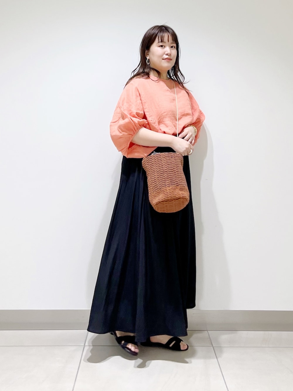 ピンク系のシャツ/ブラウス、ブラック系のスカート、ブラウン系のショルダーバッグを着用したレディースの春コーディネートの2枚目の写真