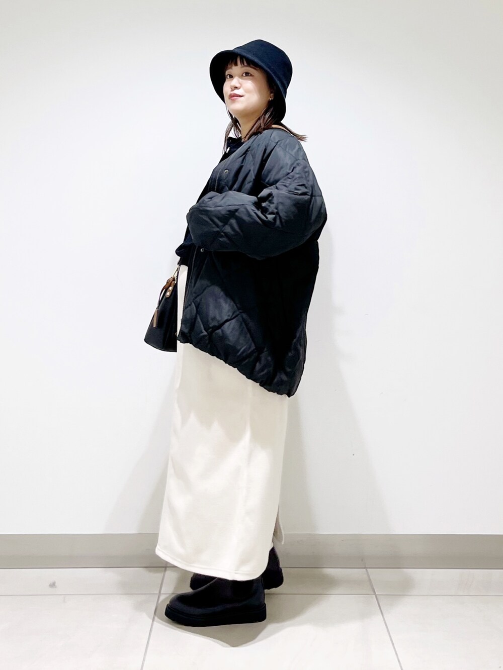 ブラック系のTシャツ/カットソー、ブラック系のその他アウター、ホワイト系のスカートを着用したレディースの秋コーディネートの6枚目の写真