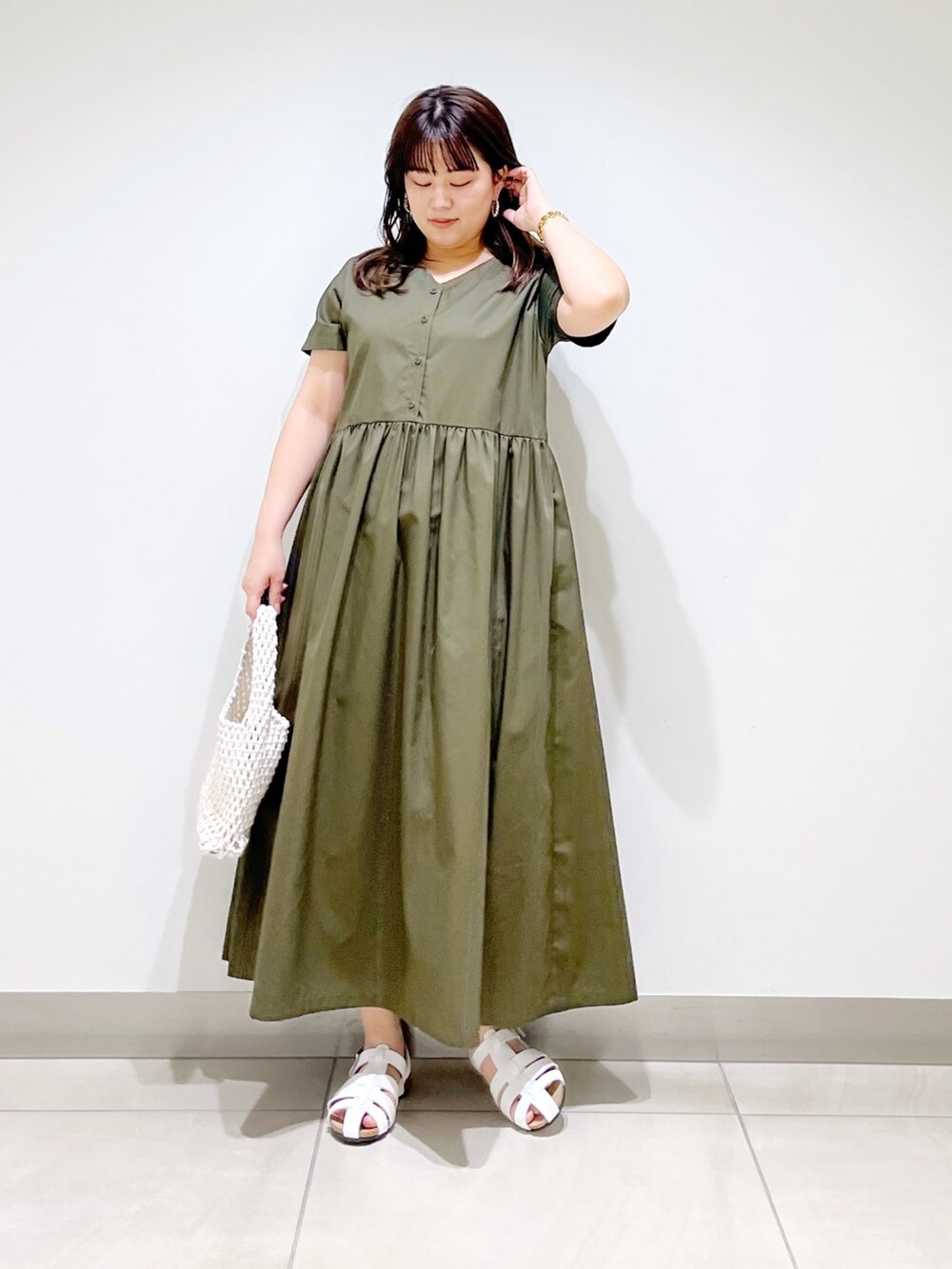 グリーン系のワンピース、ホワイト系のバッグ、ホワイト系のシューズを着用したレディースの春コーディネートの6枚目の写真