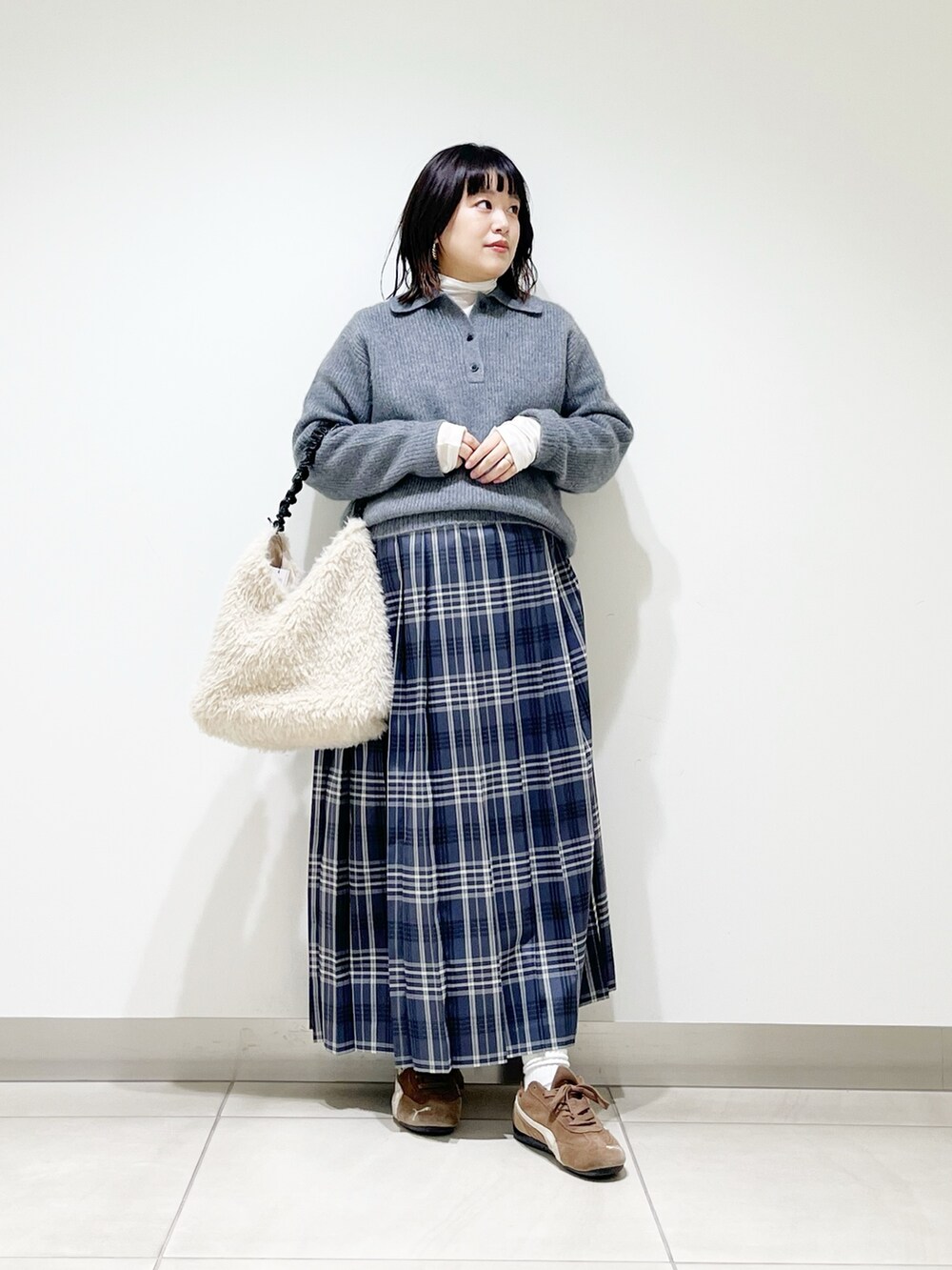 グレー系のニット/セーター、ホワイト系のTシャツ/カットソー、ホワイト系のバッグを着用したレディースの秋コーディネートの9枚目の写真