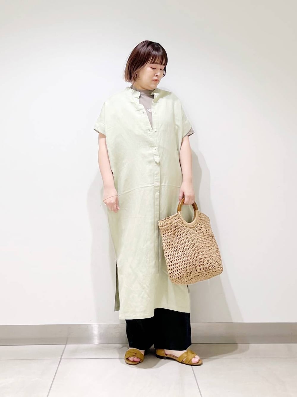ブラック系のその他パンツ、グリーン系のワンピース、ベージュ系のトートバッグを着用したレディースの春コーディネートの4枚目の写真