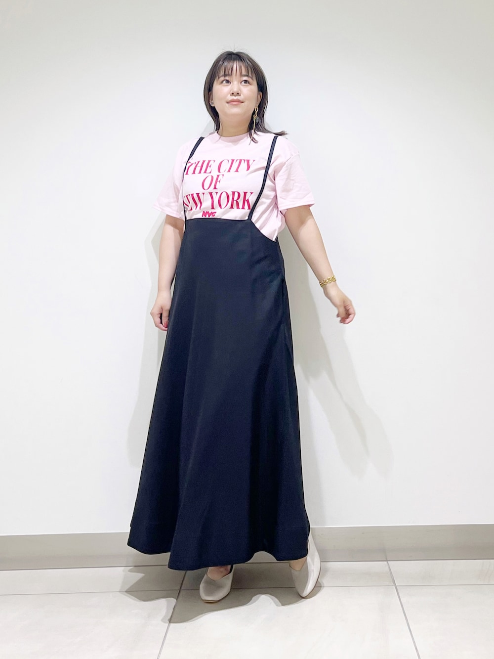 ピンク系のTシャツ/カットソー、ブラック系のスカート、ベージュ系のパンプスを着用したレディースの夏コーディネートの2枚目の写真