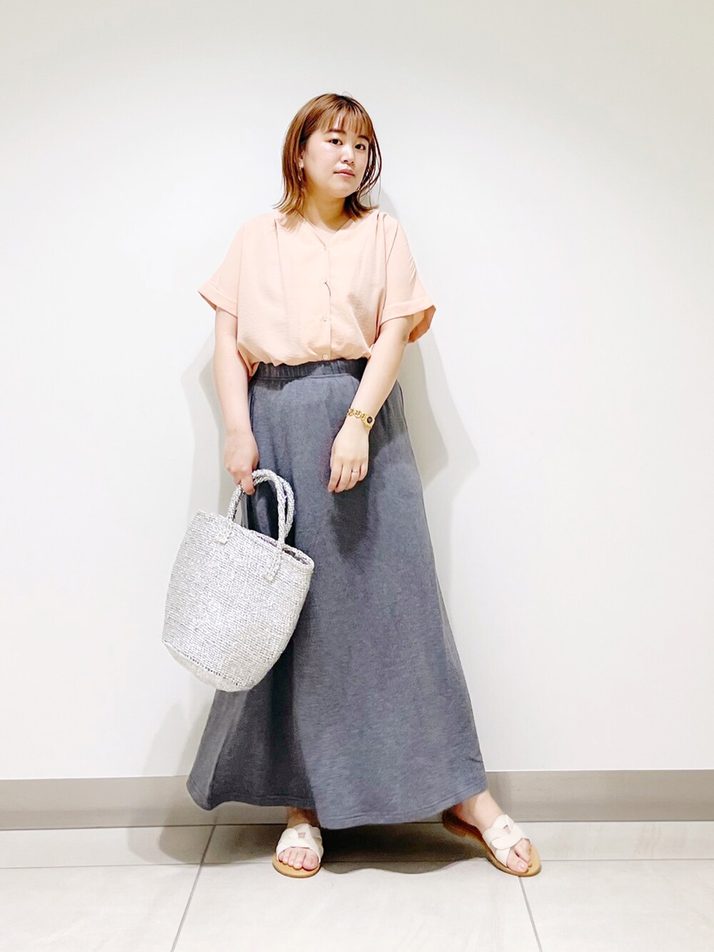 オレンジ系のシャツ/ブラウス、シルバー系のトートバッグ、グレー系のスカートを着用したレディースの春コーディネートの5枚目の写真