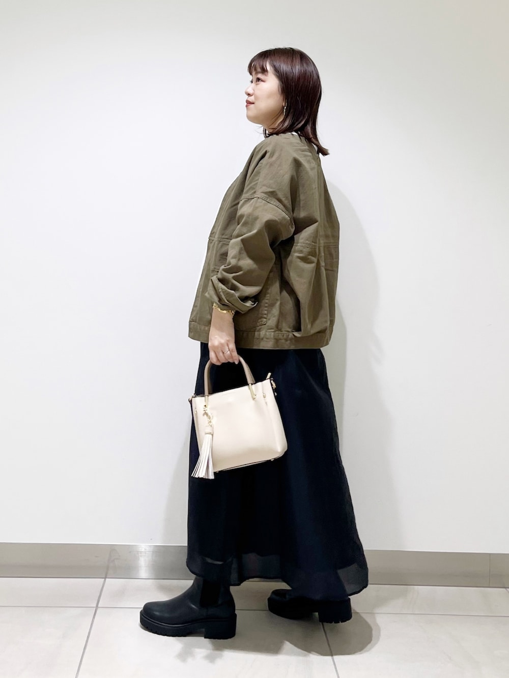 ホワイト系のTシャツ/カットソー、グリーン系のジャケット/アウター、ブラック系のスカートを着用したレディースの夏コーディネートの7枚目の写真