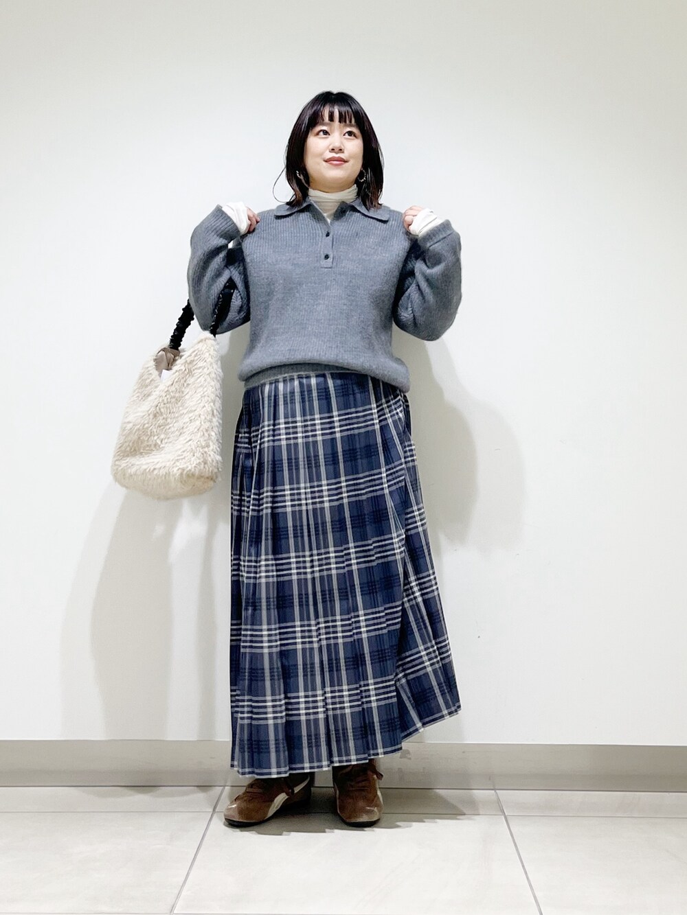 グレー系のニット/セーター、ホワイト系のTシャツ/カットソー、ホワイト系のバッグを着用したレディースの秋コーディネートの7枚目の写真