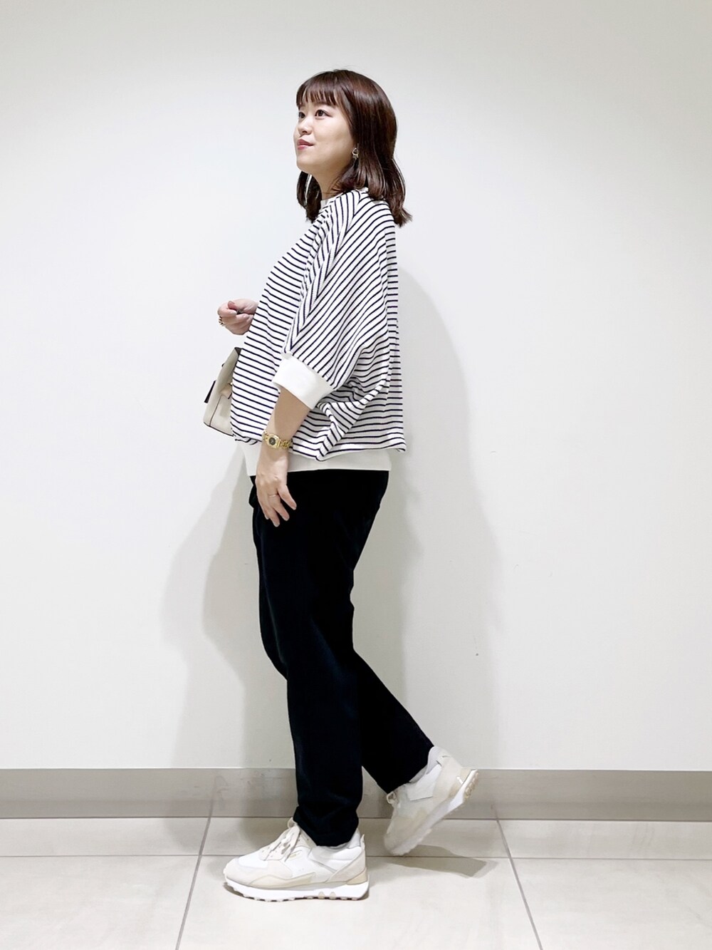 ホワイト系のTシャツ/カットソー、ブルー系のパンツ、ホワイト系のハンドバッグを着用したレディースの秋コーディネートの5枚目の写真